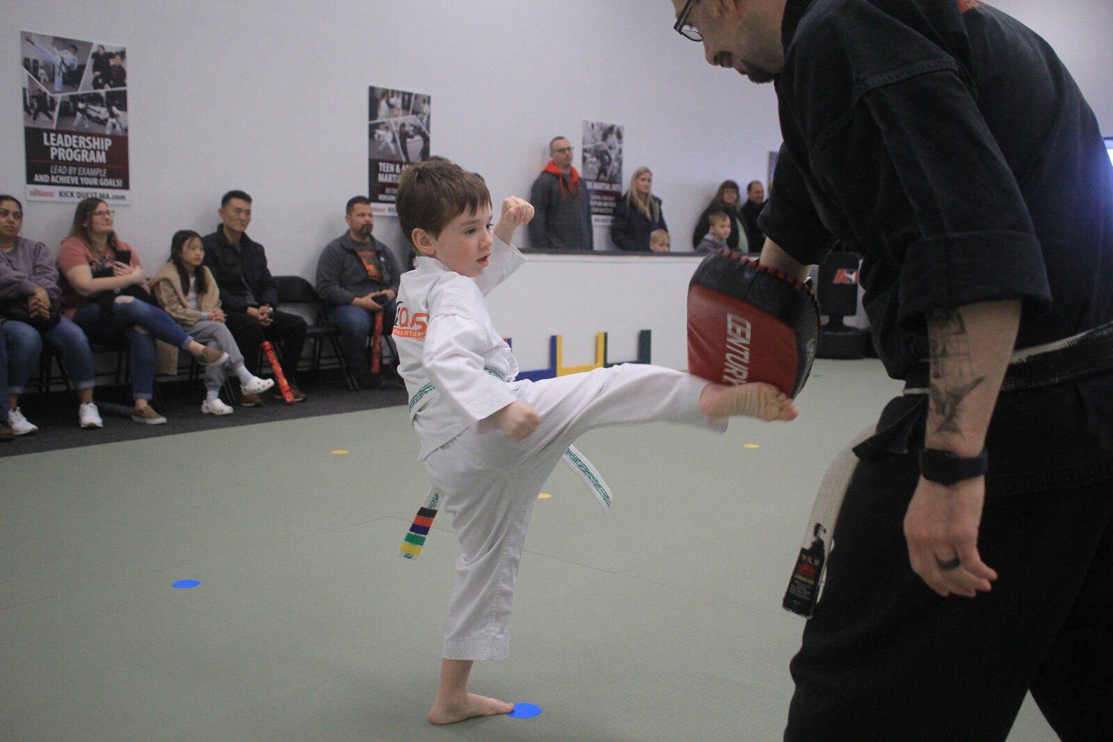 Young student in a KickQuest uniform training on the mat